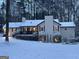 Exterior view of a charming home in winter with a snow-covered yard and mature trees at 15 Perthshire Dr, Peachtree City, GA 30269