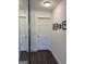 Entry hallway featuring a mirror closet, dark wooden floors, and white walls with modern decorations at 15 Perthshire Dr, Peachtree City, GA 30269