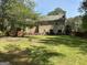 Spacious back yard featuring mature trees and a seating area at 3999 Cumberland Se Trl, Conyers, GA 30094