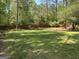 Expansive backyard featuring a well-maintained lawn, mature trees, and a wooden fence at 3999 Cumberland Se Trl, Conyers, GA 30094