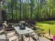 Green backyard featuring patio furniture with a fountain and a lush lawn surrounded by mature trees and a fence at 3999 Cumberland Se Trl, Conyers, GA 30094