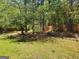 Lush backyard features a green shed, mature trees, and a wooden fence at 3999 Cumberland Se Trl, Conyers, GA 30094
