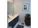 Bathroom featuring double sinks, black cabinetry, a plant, and neutral walls at 3999 Cumberland Se Trl, Conyers, GA 30094