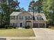 Charming two-story home featuring a stone-accented facade, lush lawn, and a two-car garage at 3999 Cumberland Se Trl, Conyers, GA 30094