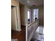 Bright upstairs hallway with hardwood floors, white railings, and open doorways at 3999 Cumberland Se Trl, Conyers, GA 30094
