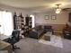 Cozy living room featuring plush gray seating, ceiling fan, bookshelves, and stylish decor at 3999 Cumberland Se Trl, Conyers, GA 30094