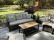 Patio features wicker furniture set including a sofa, chairs, and a coffee table, all set in a landscaped yard at 3999 Cumberland Se Trl, Conyers, GA 30094
