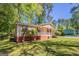 Inviting single-story home featuring a cozy front porch, complemented by a green lawn and mature trees in the background at 842 Brighton Dr, Lawrenceville, GA 30043