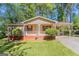 Charming single-story home with a covered porch and a carport, surrounded by lush greenery and a well-maintained lawn at 842 Brighton Dr, Lawrenceville, GA 30043