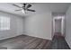 Living room featuring neutral paint, modern ceiling fan and wood-look floors leading to hallway and other rooms at 842 Brighton Dr, Lawrenceville, GA 30043