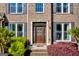 Close-up of a home's front door with decorative plants and a brick facade at 1275 Mill Shyre Way, Lawrenceville, GA 30043