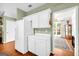 Bright kitchen featuring white cabinets, hardwood floors, and views into adjacent spaces, promoting an open feel at 1275 Mill Shyre Way, Lawrenceville, GA 30043