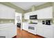 The kitchen features white cabinets, hardwood floors, and modern appliances, creating a charming culinary space at 1275 Mill Shyre Way, Lawrenceville, GA 30043