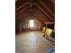 Large attic space with exposed rafters, a window and plywood flooring at 140 Julie Rd, Tyrone, GA 30290