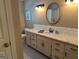 Bright bathroom with granite countertop, white cabinets, double vanity, and decorative mirror at 140 Julie Rd, Tyrone, GA 30290