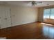 Spacious living room with hardwood flooring, ceiling fan, double doors, and large window at 140 Julie Rd, Tyrone, GA 30290