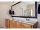 Well-lit bathroom with dual sinks, wooden cabinetry and a large mirror at 207 Jamestown Ave, Jonesboro, GA 30236