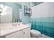Clean bathroom featuring a sink, toilet, mirror and tiled shower curtain, and blue walls at 207 Jamestown Ave, Jonesboro, GA 30236