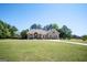 Beautiful home featuring lush greenery, a large front yard, and a long driveway at 207 Jamestown Ave, Jonesboro, GA 30236