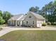 Gorgeous home with attached two-car garage and circular driveway surrounded by lush greenery at 207 Jamestown Ave, Jonesboro, GA 30236