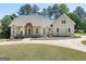 Stunning home featuring a stone archway entrance, manicured lawn, and a circular driveway at 207 Jamestown Ave, Jonesboro, GA 30236