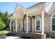Inviting front porch featuring stone accents, white columns, and comfortable rocking chairs at 207 Jamestown Ave, Jonesboro, GA 30236