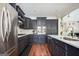 Bright kitchen with stainless steel appliances, dark cabinets, tile backsplash and a view of the living area at 207 Jamestown Ave, Jonesboro, GA 30236