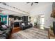 Open-concept living room featuring a leather sofa and hardwood floors, seamlessly flowing into the modern black kitchen at 207 Jamestown Ave, Jonesboro, GA 30236