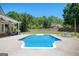 Large in-ground pool with a spacious patio area and covered seating, surrounded by lush landscaping and blue skies at 207 Jamestown Ave, Jonesboro, GA 30236
