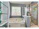 Bright bathroom featuring a large tub, window and a standup shower at 7750 Carnegie Dr, Fairburn, GA 30213