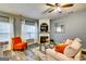 Cozy living room with fireplace, bright windows, wood floors, and a ceiling fan at 7750 Carnegie Dr, Fairburn, GA 30213