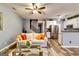 Open-concept living area with wood floors, ceiling fan, and stainless steel appliances at 7750 Carnegie Dr, Fairburn, GA 30213