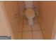 Close up of bathroom toilet and tiled flooring, illuminated by soft, natural light at 7541 Coddington Ct, Riverdale, GA 30274