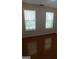 Bedroom features hardwood flooring, neutral paint, and two windows with natural light at 7541 Coddington Ct, Riverdale, GA 30274