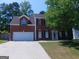 Charming two-story brick home featuring a well-manicured lawn and attached garage at 7541 Coddington Ct, Riverdale, GA 30274