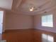 Spacious main bedroom with tray ceiling, hardwood floors, and a large window at 7541 Coddington Ct, Riverdale, GA 30274