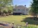 Large backyard featuring well-maintained lawn, wooden fence, and a screened porch at 514 Augusta Dr, Canton, GA 30115