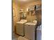 Well-lit laundry room features a modern washer and dryer, plus ample shelf storage for supplies at 514 Augusta Dr, Canton, GA 30115