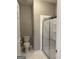 Full bathroom featuring tile flooring, a shower with glass doors, and a toilet at 203 Collierstown Way, Peachtree City, GA 30269
