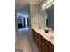 Bathroom featuring a double sink vanity with wood cabinets, mirror, and view into the bedroom at 203 Collierstown Way, Peachtree City, GA 30269