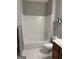 Bathroom featuring tile flooring, a bathtub with white tile surround, and a toilet at 203 Collierstown Way, Peachtree City, GA 30269