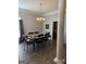 Formal dining room featuring an elegant chandelier, a dark table with six chairs, and wood flooring at 203 Collierstown Way, Peachtree City, GA 30269