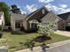 Charming home with stone accents, manicured lawn, and a blossoming tree in the front yard at 203 Collierstown Way, Peachtree City, GA 30269