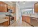 Kitchen featuring stainless steel appliances, wooden cabinetry, and granite countertops at 203 Collierstown Way, Peachtree City, GA 30269