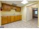 Basement kitchenette area with wooden cabinets, sink, tile floors, and a closet at 6205 Collingham Trce, Cumming, GA 30040
