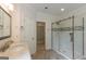 Bright bathroom featuring a marble vanity, a glass-enclosed shower and a door leading to another room at 6205 Collingham Trce, Cumming, GA 30040