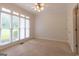Bright bedroom featuring neutral carpet, a ceiling fan, and many large windows offering ample natural light at 6205 Collingham Trce, Cumming, GA 30040