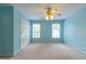 Light blue bedroom includes two windows and a ceiling fan at 6205 Collingham Trce, Cumming, GA 30040