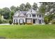 Inviting two-story home featuring a lush green lawn, beautiful landscaping, and a classic architectural design at 6205 Collingham Trce, Cumming, GA 30040