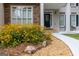 Charming home entrance with stone accents, vibrant yellow flowers, and a well-manicured landscape at 6205 Collingham Trce, Cumming, GA 30040